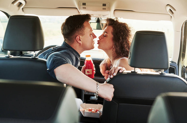 Love and food. Beautiful people is in the modern car at their weekends. - Fotó, kép