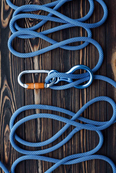 This things is ready for use. Isolated photo of climbing equipment. Parts of carabiners lying on the wooden table. - Foto, immagini