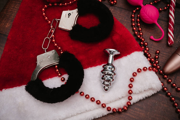 クリスマスの装飾が施された大人のbdsmおもちゃのセット。フラトリー。手錠、アナルプラグ、クリスマスボール. - 写真・画像