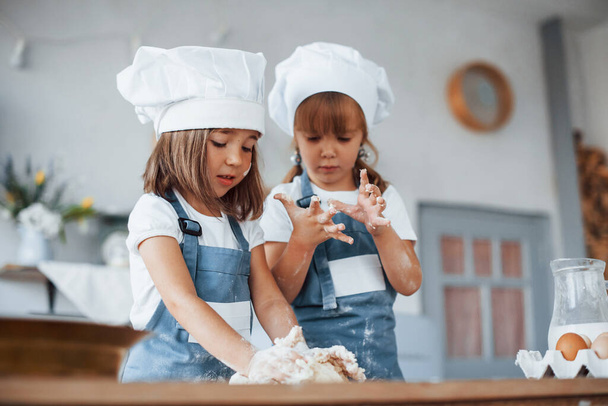 Family kids in white chef uniform preparing food on the kitchen. - Photo, image