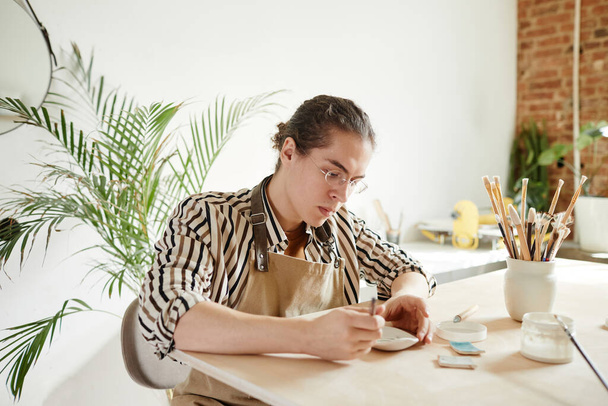 Молодий чоловік у гончарній майстерні - Фото, зображення