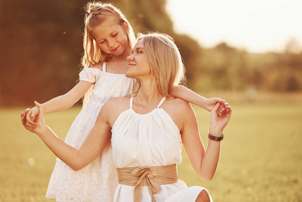 Calm and quiet. Mother and daughter enjoying weekend together by walking outdoors in the field. Beautiful nature. - Photo, Image
