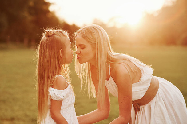 She loves her child. Mother and daughter enjoying weekend together by walking outdoors in the field. Beautiful nature. - Foto, Bild