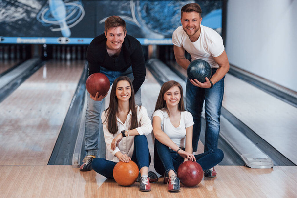 Nice portrait. Young cheerful friends have fun in bowling club at their weekends. - Foto, Imagem