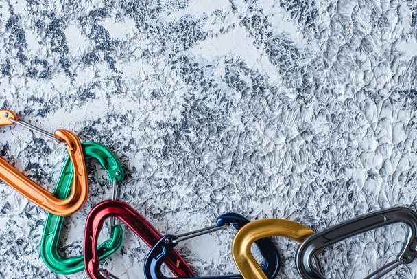 Usable devices for hiking. Isolated photo of climbing equipment. Part of carabiner lying on the white and grey colored surface. - Фото, изображение