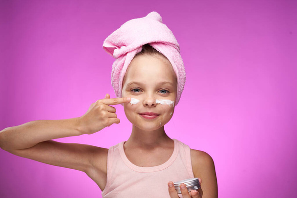 girl with a towel on her head cosmetics decoration close-up purple background - Photo, image