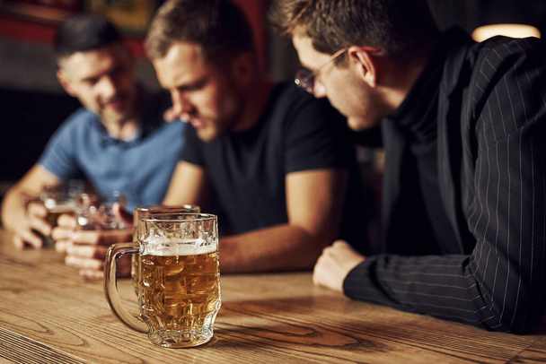 Three male friends in the bar. Supporting sad friend. Unity of people. With beer on the table. - Photo, image