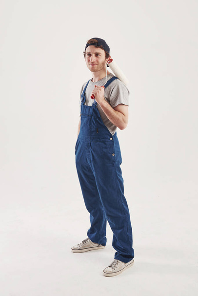 Happy face expression. Man in blue uniform stands against white background in the studio. - Foto, immagini