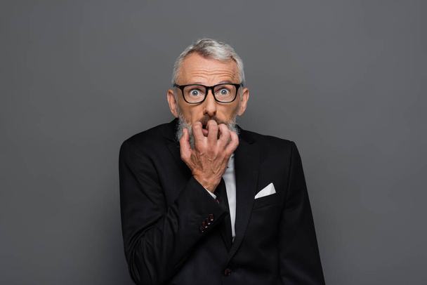 scared middle aged businessman in glasses gesturing isolated on grey - Photo, Image