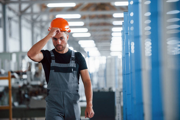 Taking off hard hat. After the work. Industrial worker indoors in factory. Young technician. - Foto, Bild