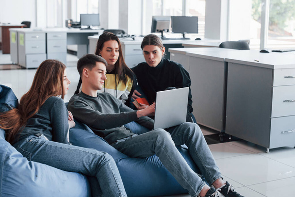 Look what I've found. Group of young people in casual clothes working in the modern office. - Foto, afbeelding