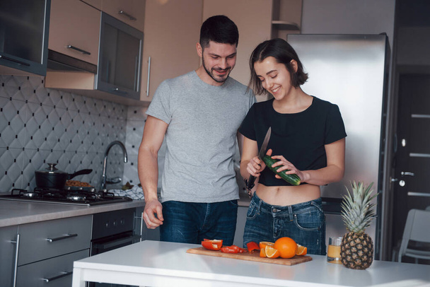 Sincere smiles. Young couple in the modern kitchen at home at their weekend time in the morning. - Foto, imagen