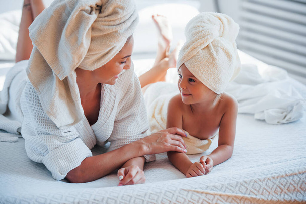 Young mother with her daugher have beauty day indoors in white room. - Foto, Bild