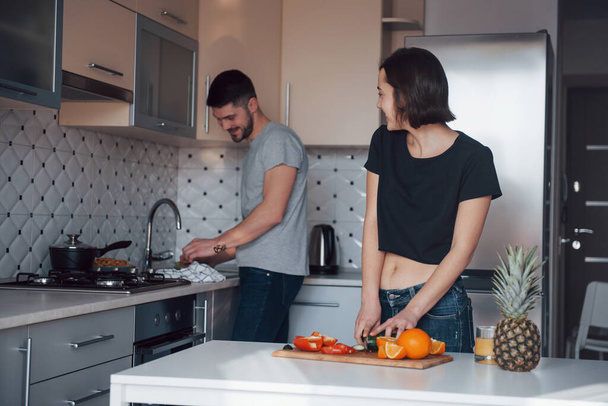 Conversation between two people. Young couple in the modern kitchen at home at their weekend time in the morning. - Foto, Bild