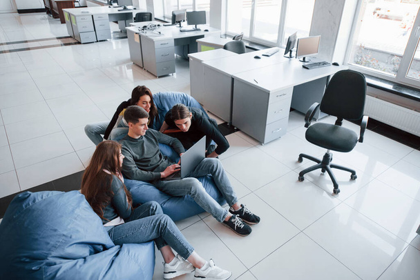 Need to look closer. Group of young people in casual clothes working in the modern office. - Foto, imagen