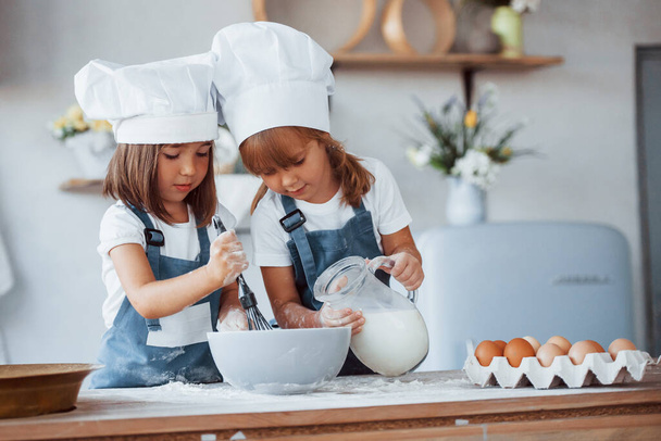 Family kids in white chef uniform preparing food on the kitchen. - Foto, Imagen
