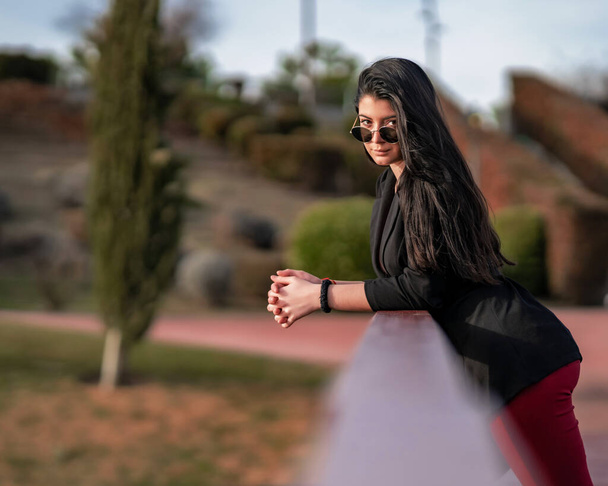 mujer joven y atractiva posando en un parque al aire libre, pasandoselo bien en una sesion de fotos - Foto, Bild