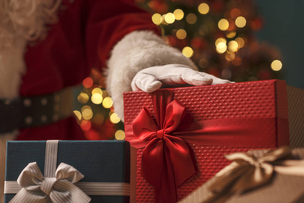 Weihnachtsmann zeigt schöne Weihnachtsgeschenke zu Hause, Feiertage und Feiertage - Foto, Bild