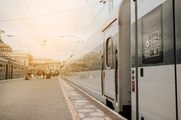 Tren interurbano moderno en la plataforma ferroviaria al atardecer en Europa.Concepto de viaje - Foto, imagen