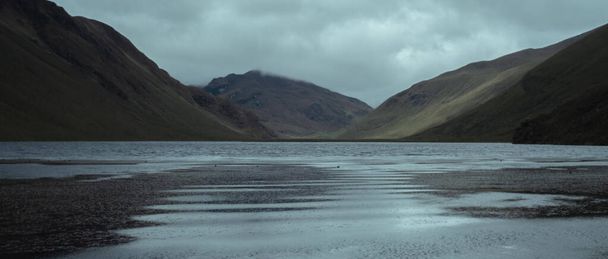 The cloudy sky over the Andean lagoon in the middle of the mountains - Foto, Imagen