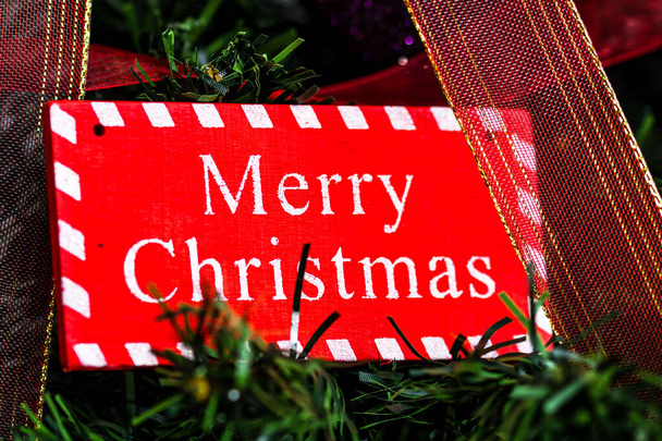 Een rode Merry Christmas houten bord opknoping op de boom - Foto, afbeelding