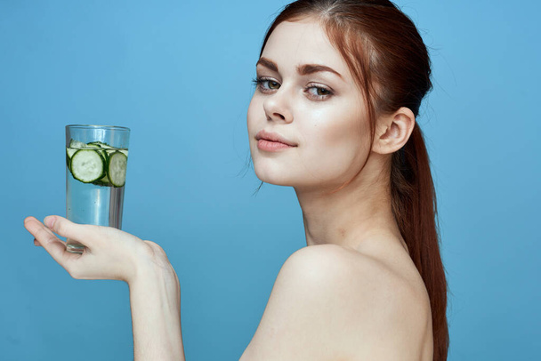 woman with bared shoulders cucumber health drink blue background - Photo, Image