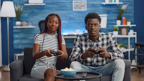 Afroamerikaner spielen Videospiel mit Joysticks - Foto, Bild
