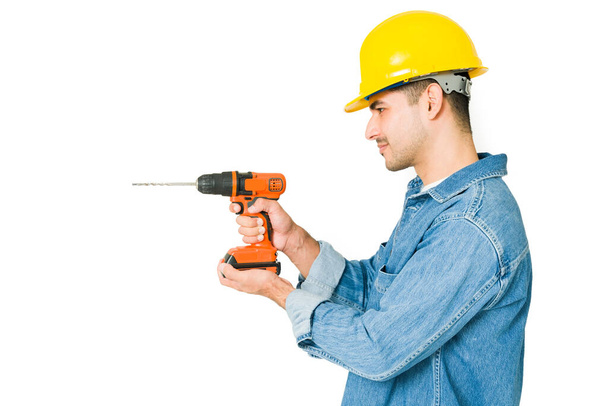 Professional contractor drilling on a wall against a white background. Handyman doing some renovations  - Foto, Imagem