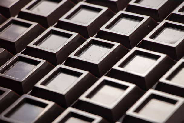Close up a chocolate bar background. Chocolate bar cubes macro. - Zdjęcie, obraz