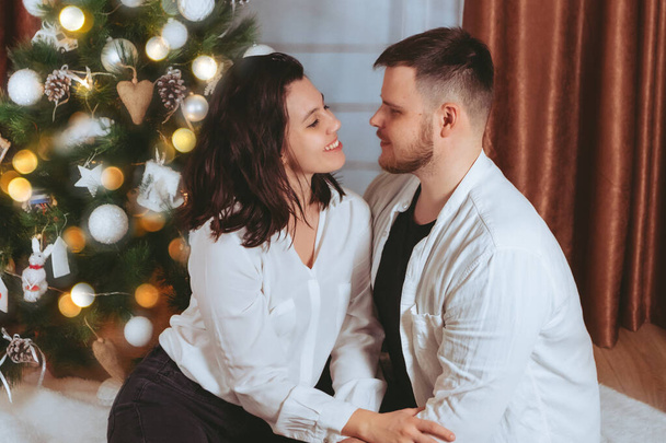 couple shooting in front of decorated christmas tree copy space gift card - Fotoğraf, Görsel