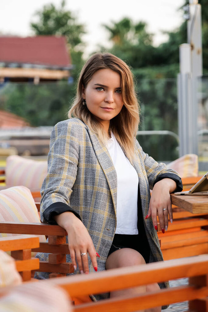 Charming young business lady sitting at the table outdoors - Fotografie, Obrázek