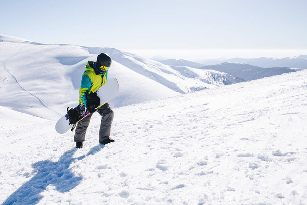 muž snowboardista na vrcholu hor krásný výhled na pozadí - Fotografie, Obrázek