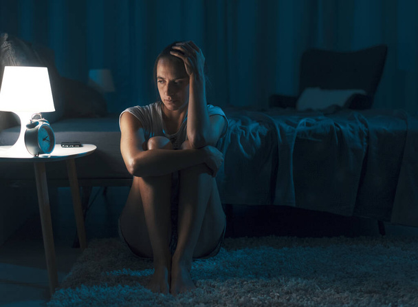 Depressed sleepless woman staring at the alarm clock, she can't sleep and suffers from insomnia - Fotoğraf, Görsel