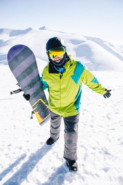 man snowboarder at the top of the mountains beautiful view on background - Photo, image