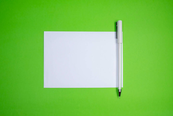 biała koperta i długopis na zielonym tle. Napisz list i gratulacje, wolne miejsce, miejsce na tekst - Zdjęcie, obraz