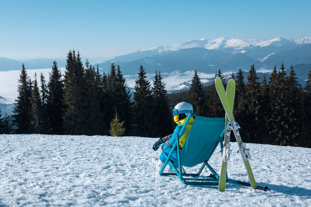 жінка лижниця сидить у кріслі з красивими горами з панорамним видом на гірськолижний курорт. зимові канікули
 - Фото, зображення