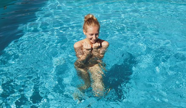 Belle jeune femme nue dans la piscine. Jeune blonde nue nage dans la piscine extérieure - Photo, image