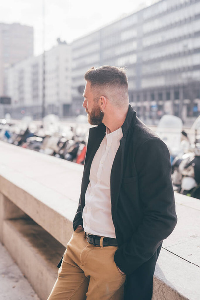 Young bearded caucasian successful business man outdoors posing confident and thoughtful overlooking  - Photo, Image