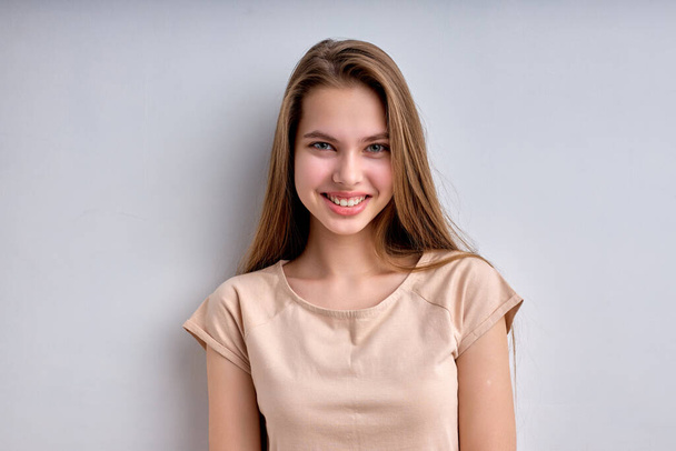 Portrait of beautiful teenage girl isolated on white background, smiling happily - Foto, afbeelding