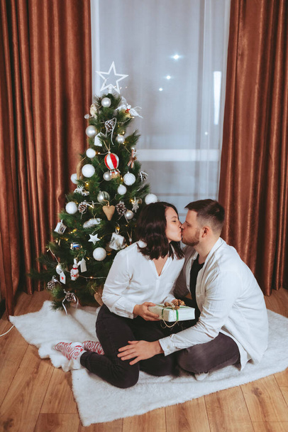 couple shooting in front of decorated christmas tree copy space gift card - 写真・画像