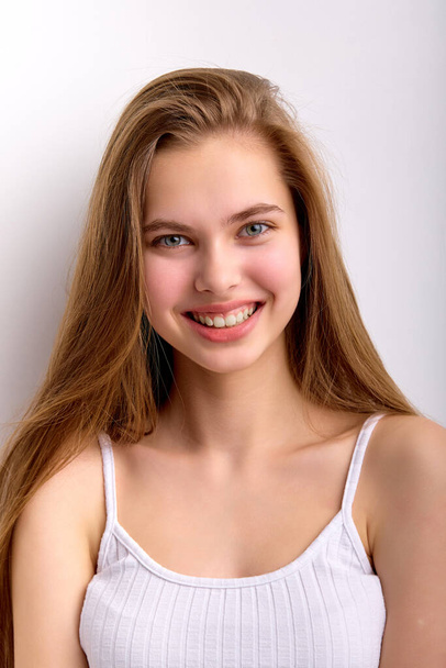 portrait of cheerful caucasian female with long natural hair looking at camera happily - Foto, afbeelding