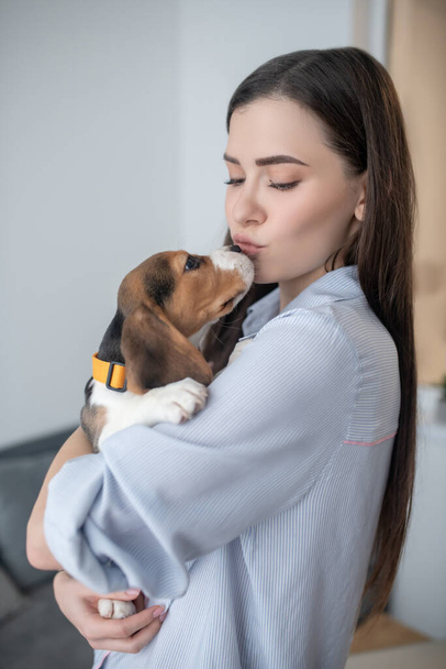 Pet owner holding her cute puppy and looking happy - Fotó, kép