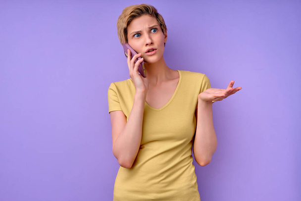 Clueless Caucasian woman talk on phone shrugs shoulders with hesitation, doubtful situation - Φωτογραφία, εικόνα