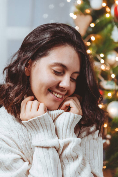 Nainen valkoisessa puserossa poseeraa lähellä joulukuusi muotokuva - Valokuva, kuva