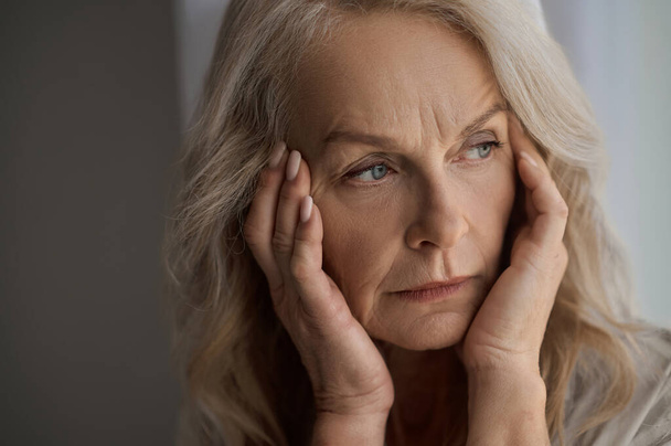 Sad mature woman suffering from a headache - Zdjęcie, obraz