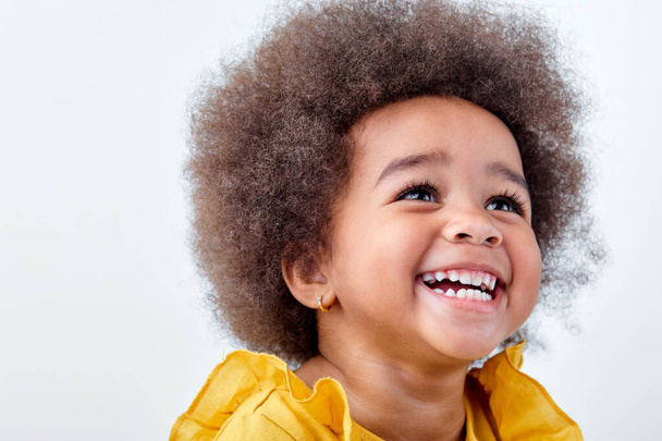 Excited little afro black girl isolated on white studio background, having fun - Фото, зображення