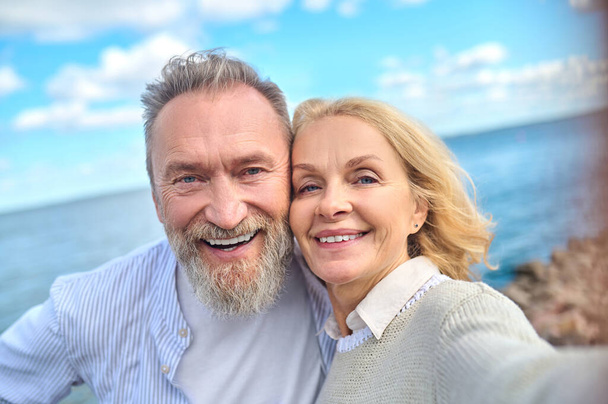 Smiling man and woman looking at camera - Фото, изображение