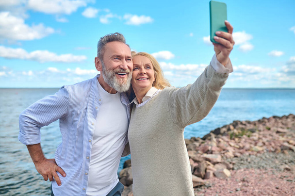 Woman with smartphone taking selfie with man - Zdjęcie, obraz