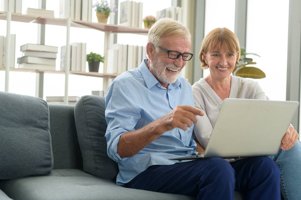 Happy Caucasian senior couple using laptop at home - Foto, imagen
