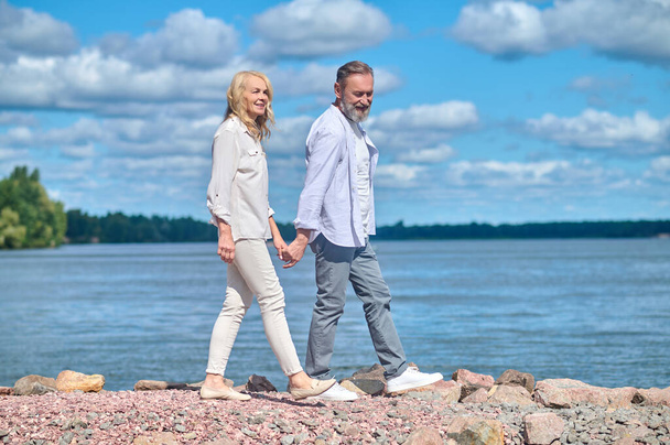 Cheerful man and woman on walk by sea - Zdjęcie, obraz